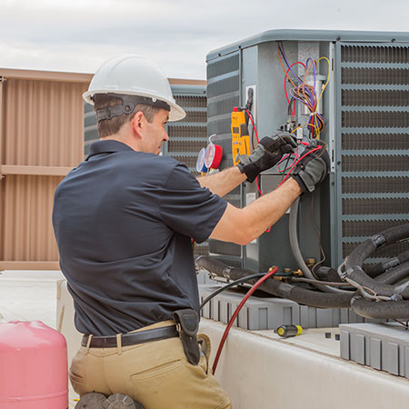 Man in Hardhat Working on Outdoor HVAC